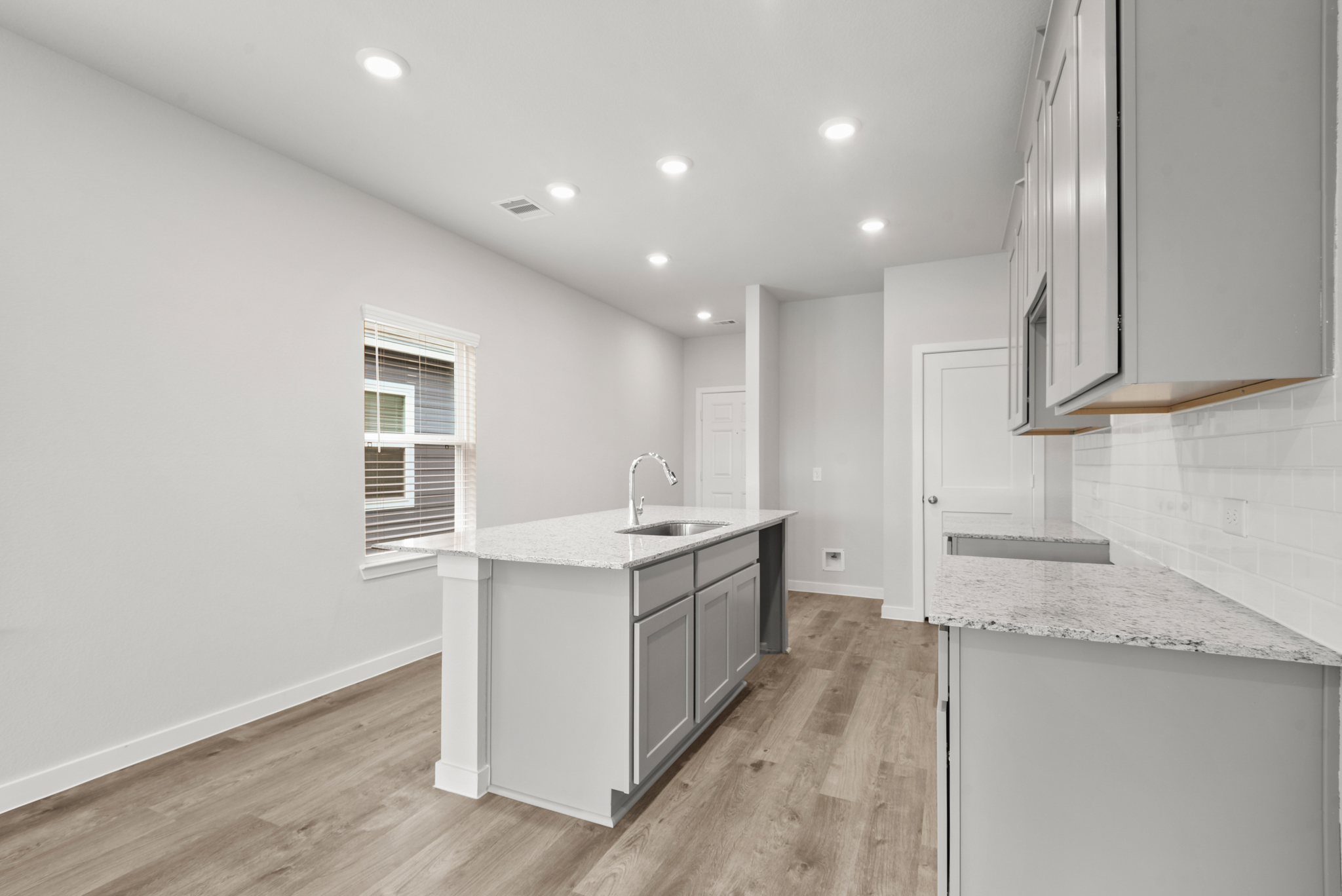 A kitchen with white cabinets.
