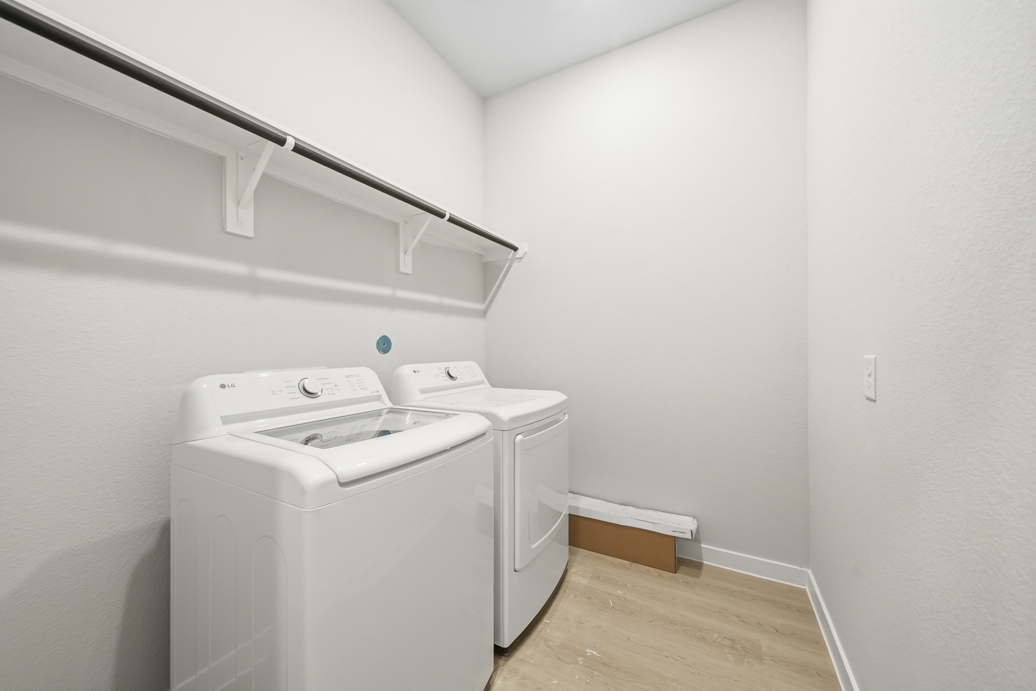 A white laundry machine in a room.