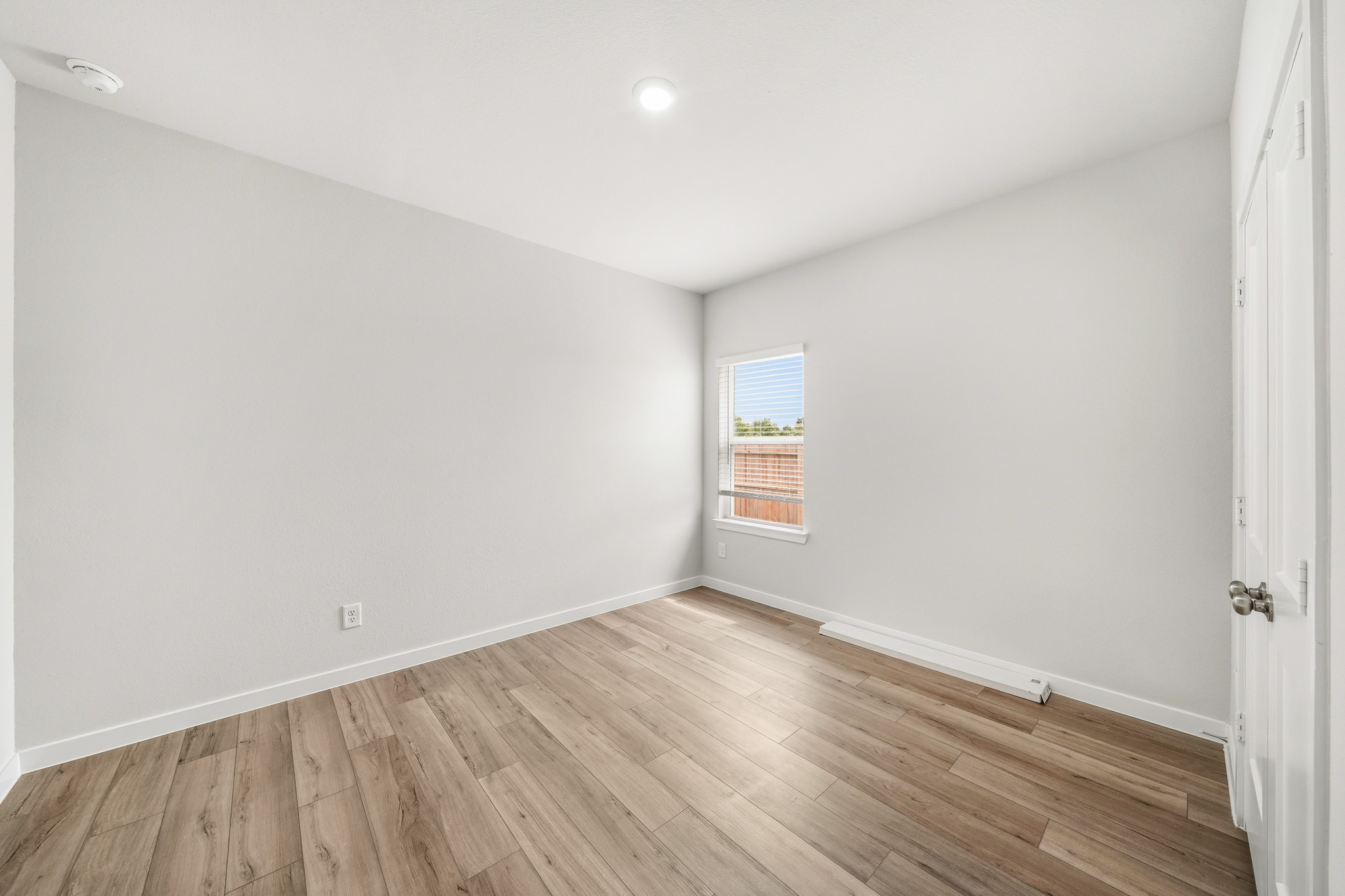 A room with a wood floor and a window.