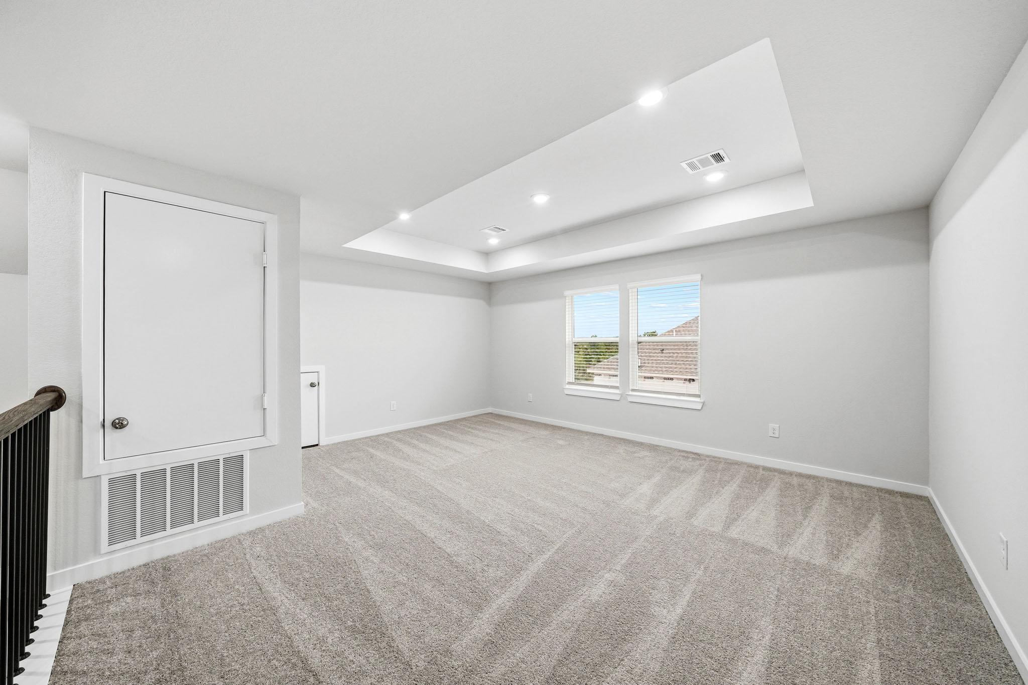 A room with a carpet and a window.