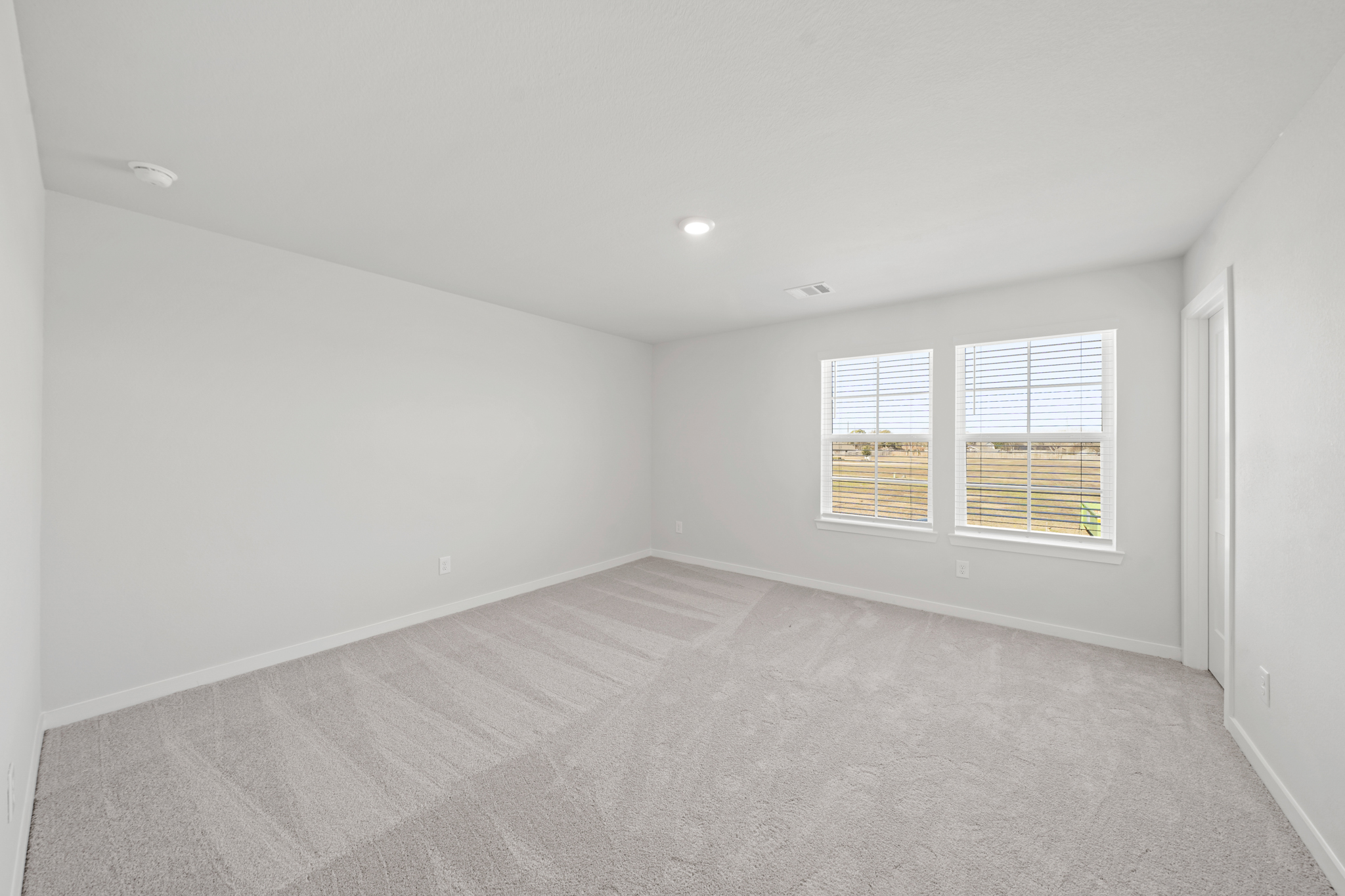 A room with a carpet and windows.