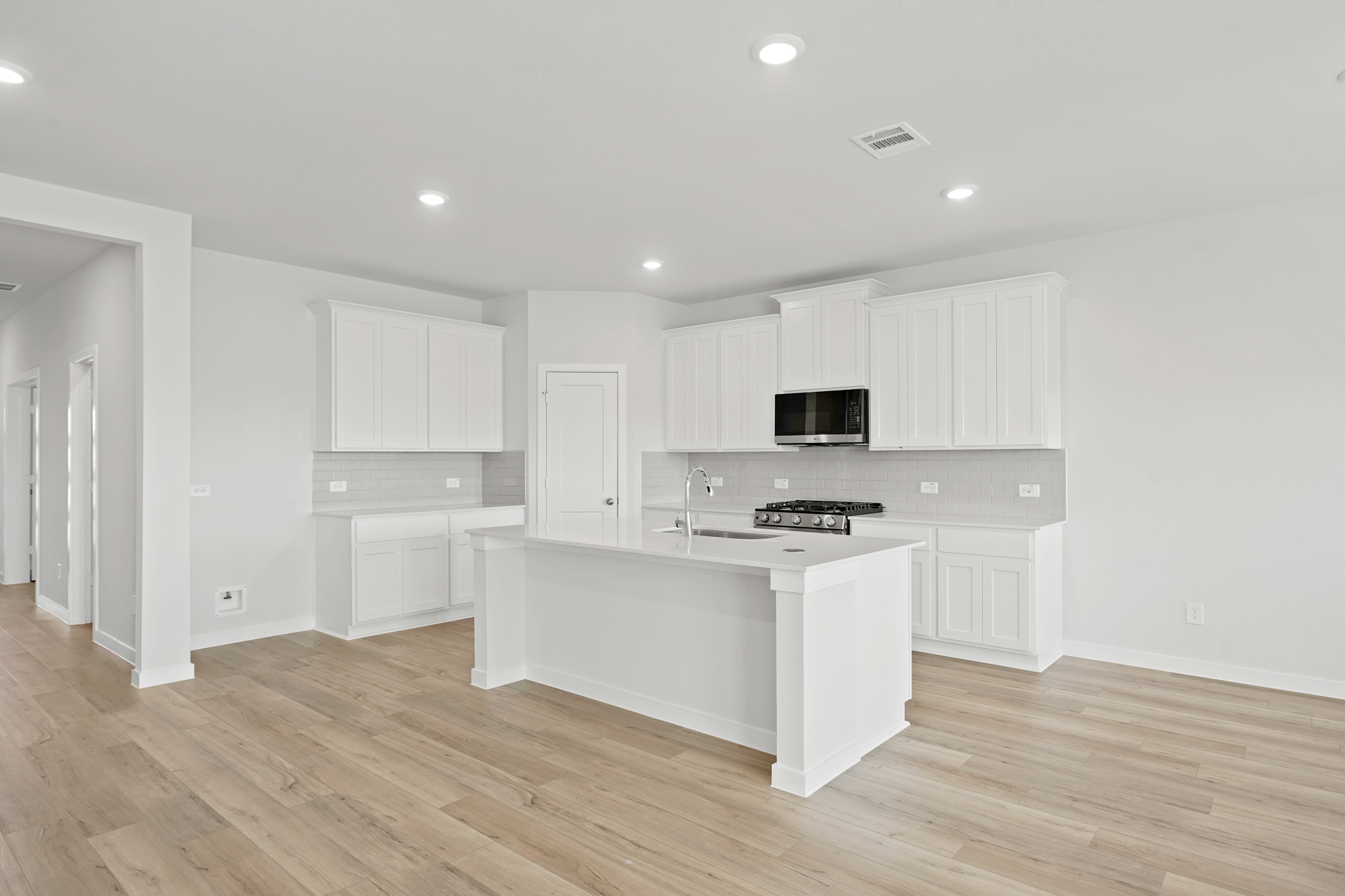 A kitchen with white cabinets.