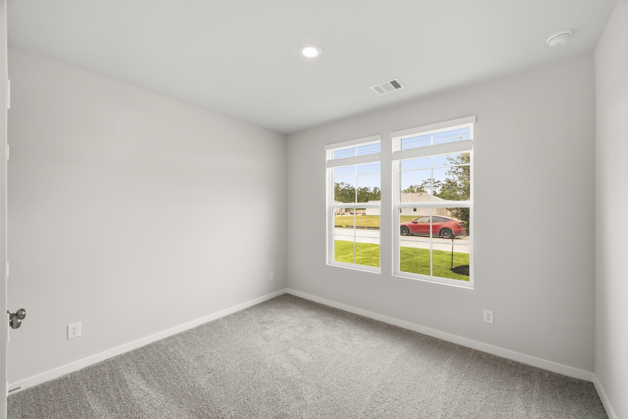 A room with a window and a car outside.