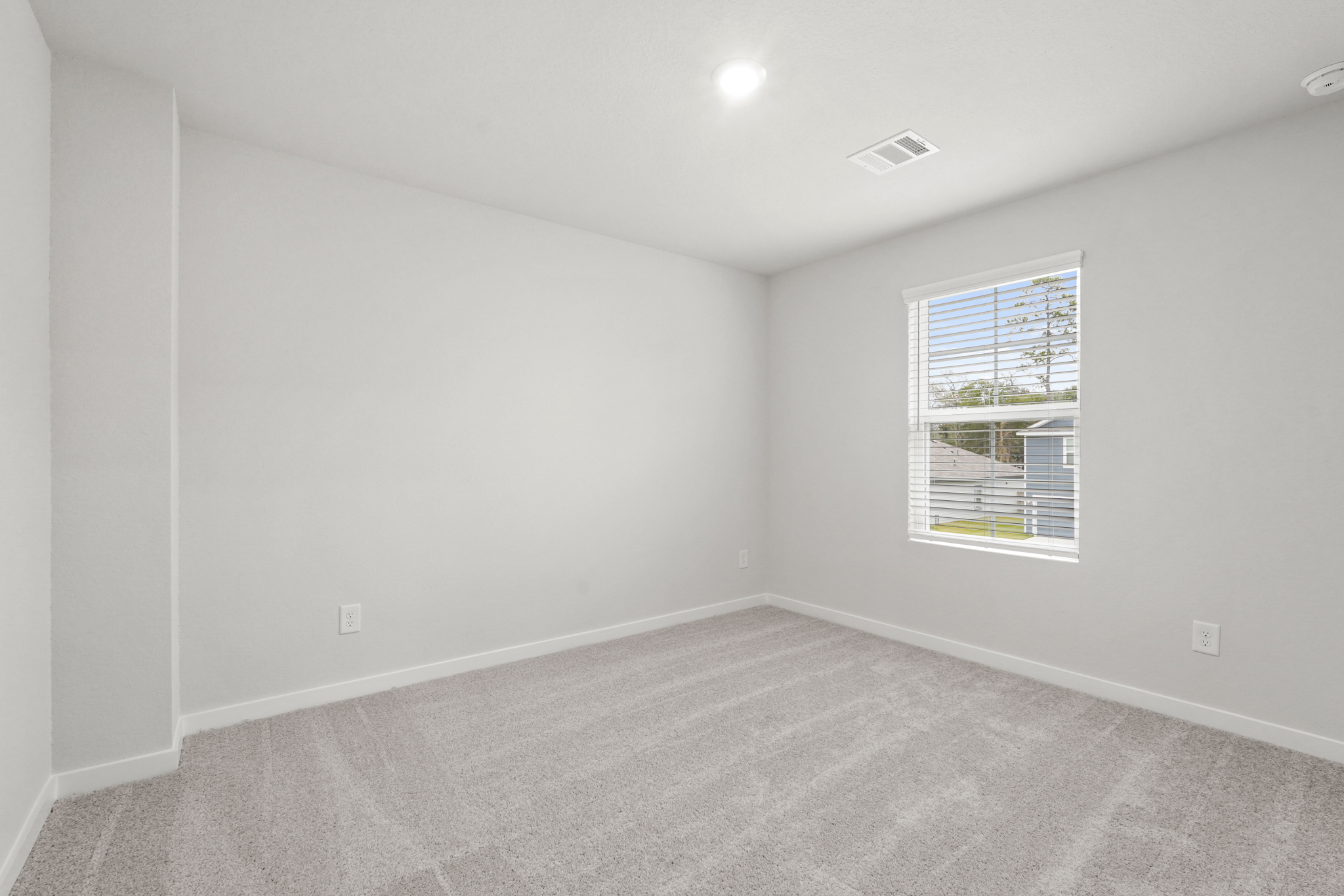 A room with a window and a carpet.