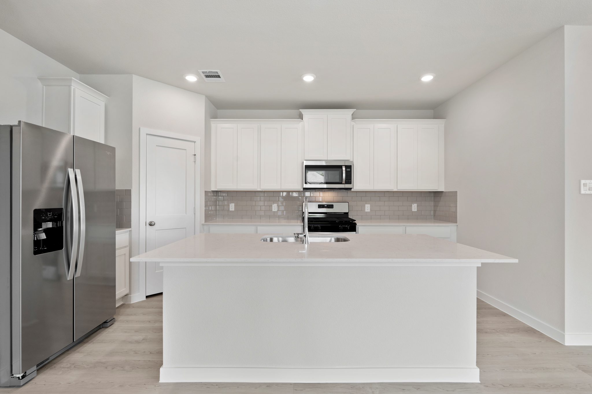 A kitchen with white cabinets.