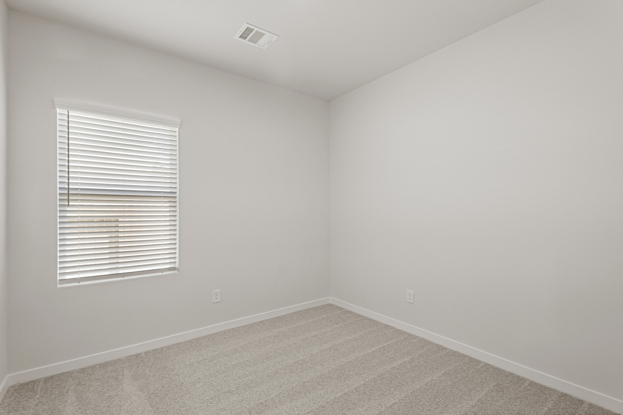 A room with a window and a carpet.