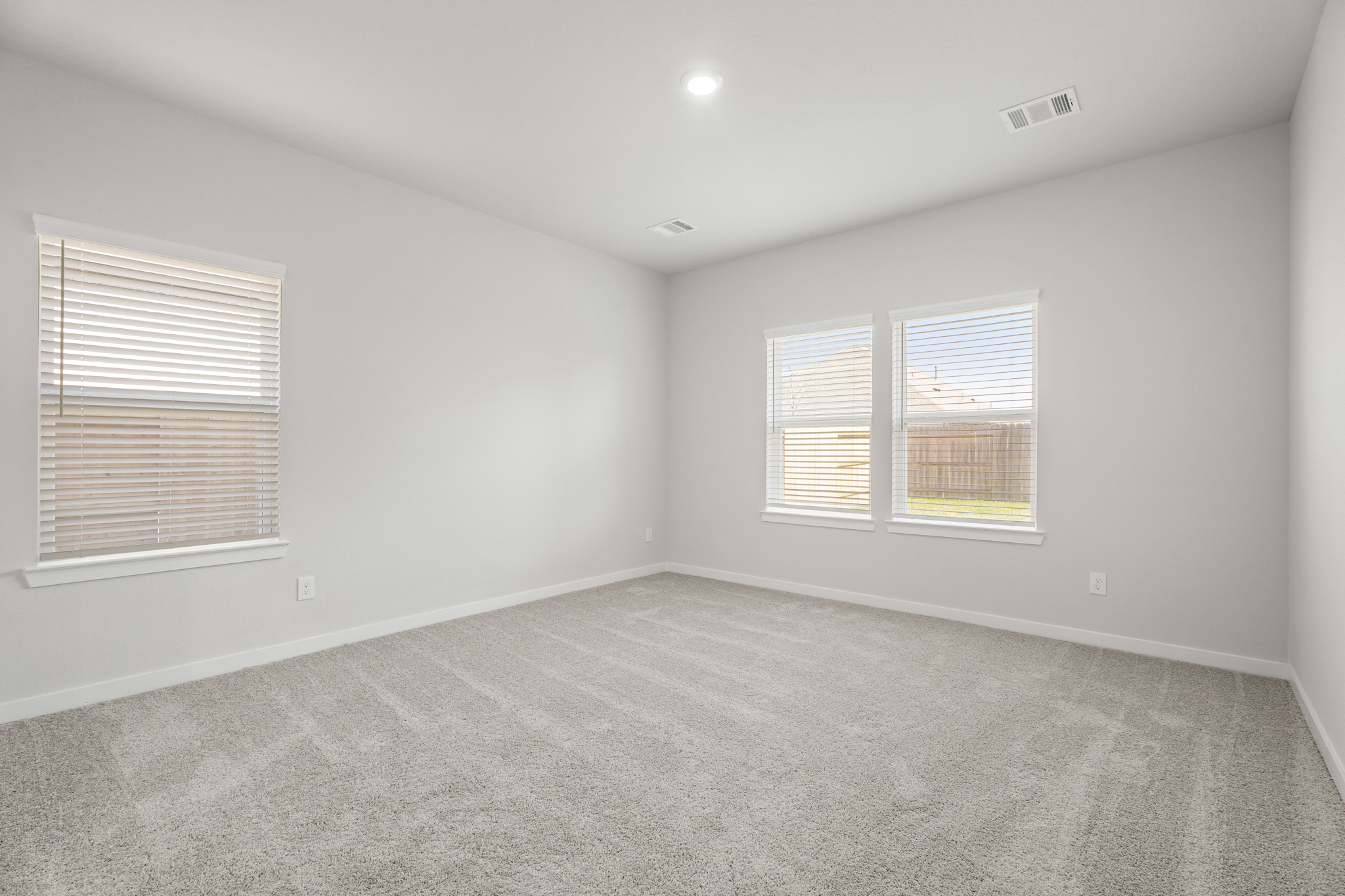 A room with a carpet and windows.