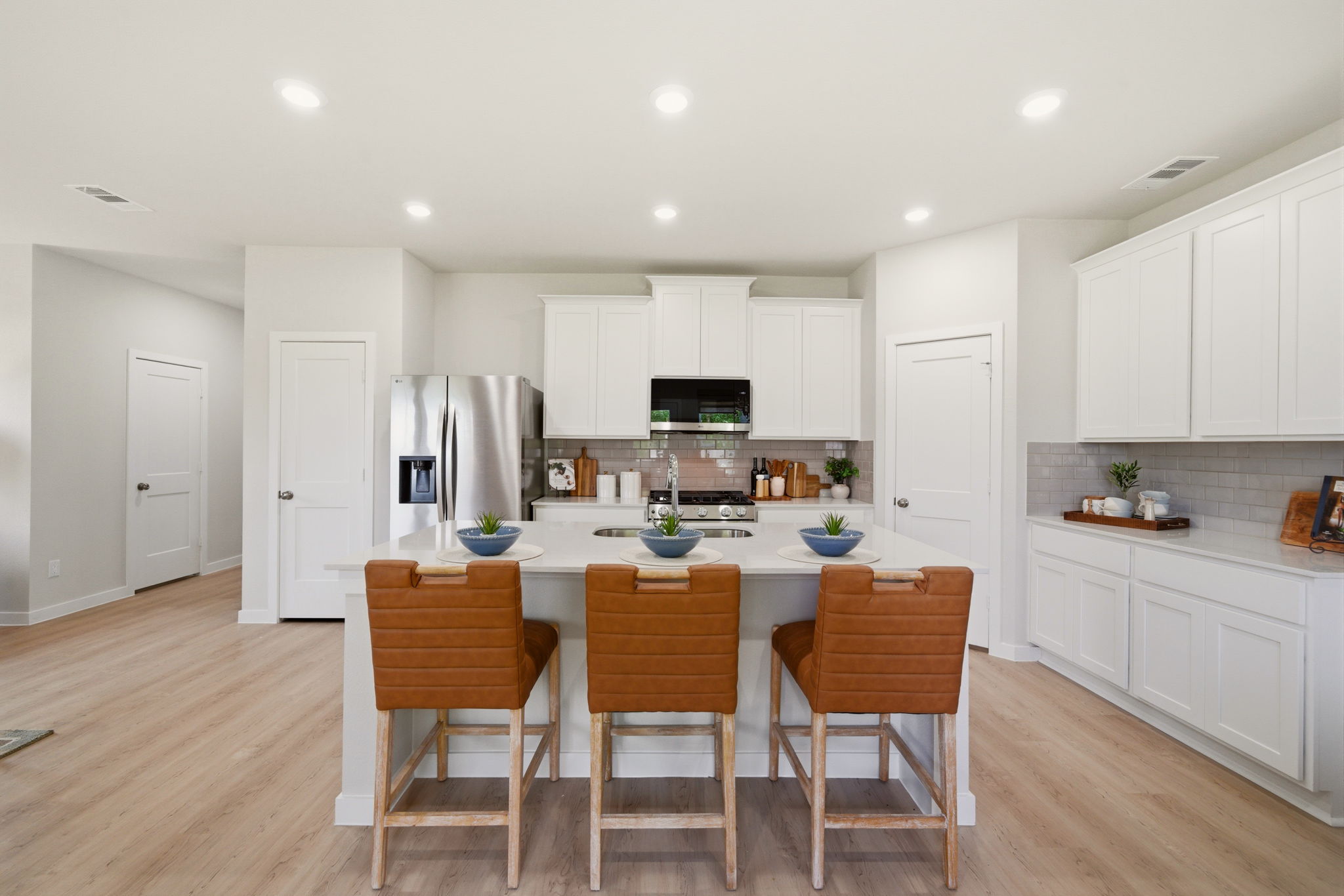 A kitchen with white cabinets.