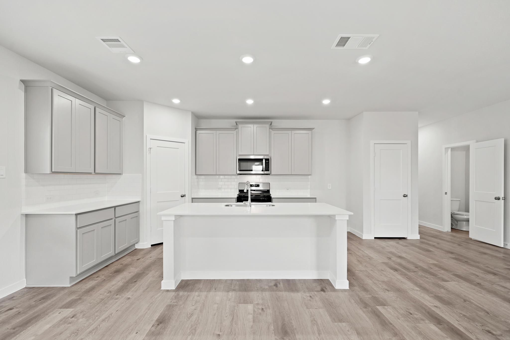 A kitchen with white cabinets.