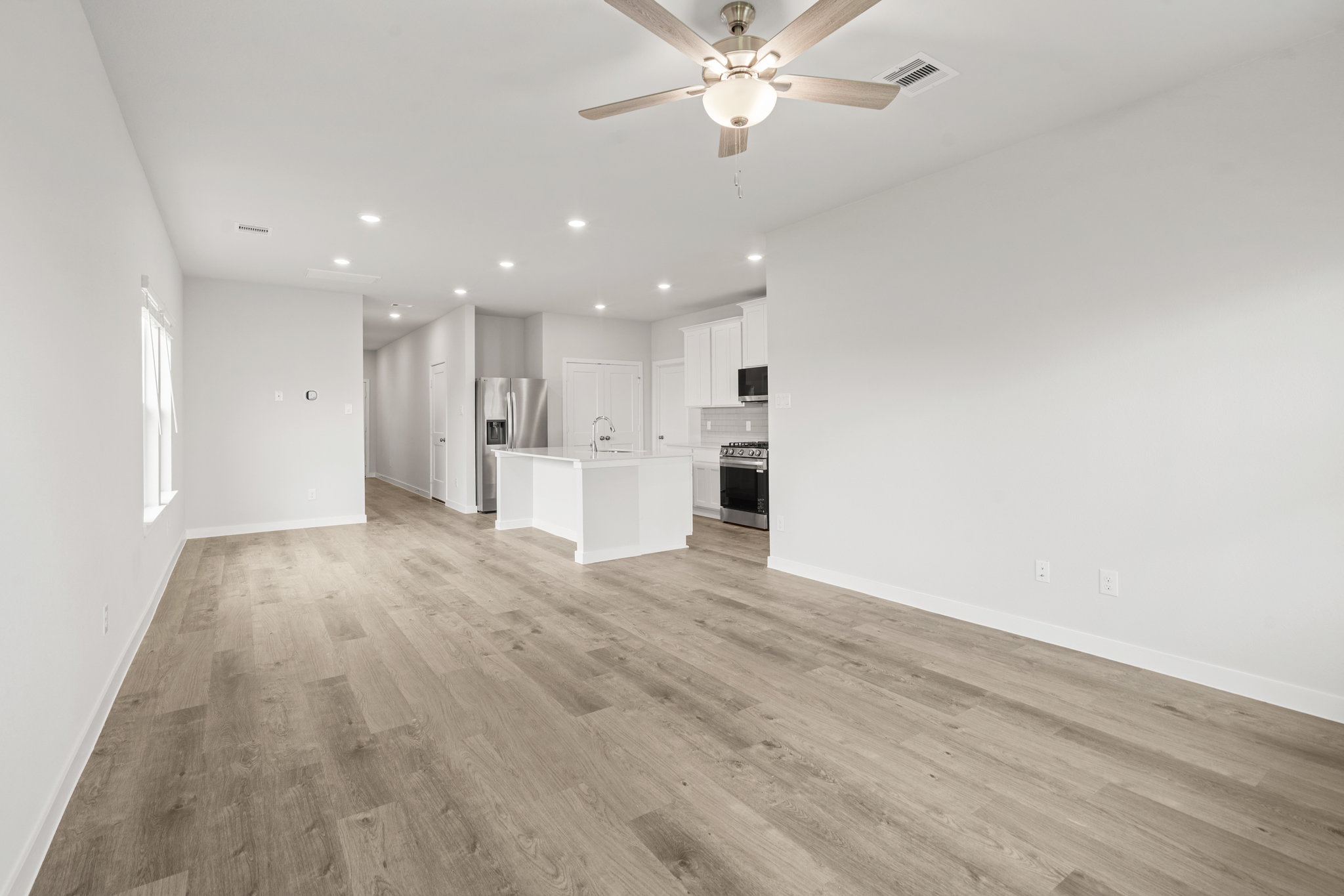 A large kitchen with a wood floor.