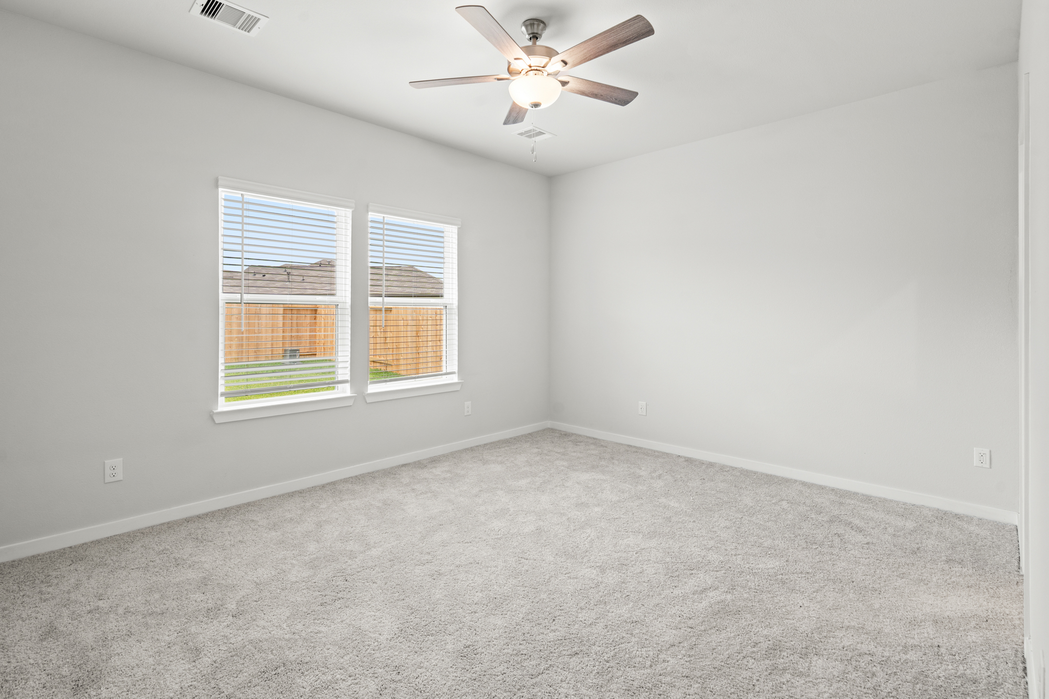 A room with a ceiling fan and a window.