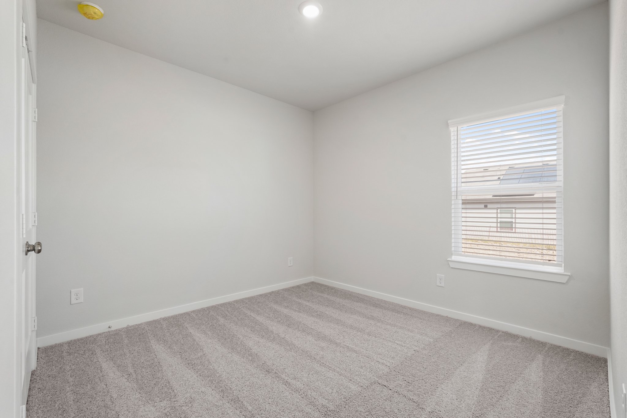 A room with a window and a carpet.