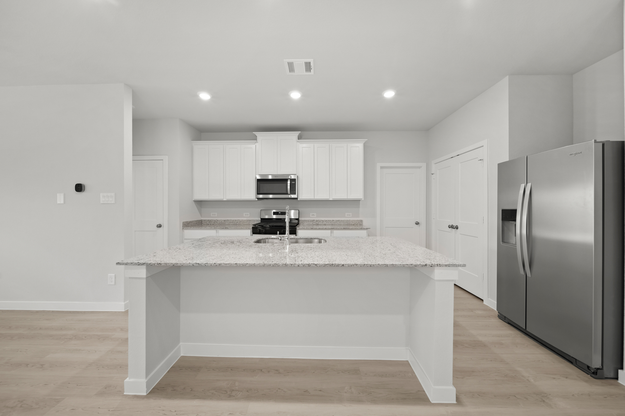 A kitchen with white cabinets.