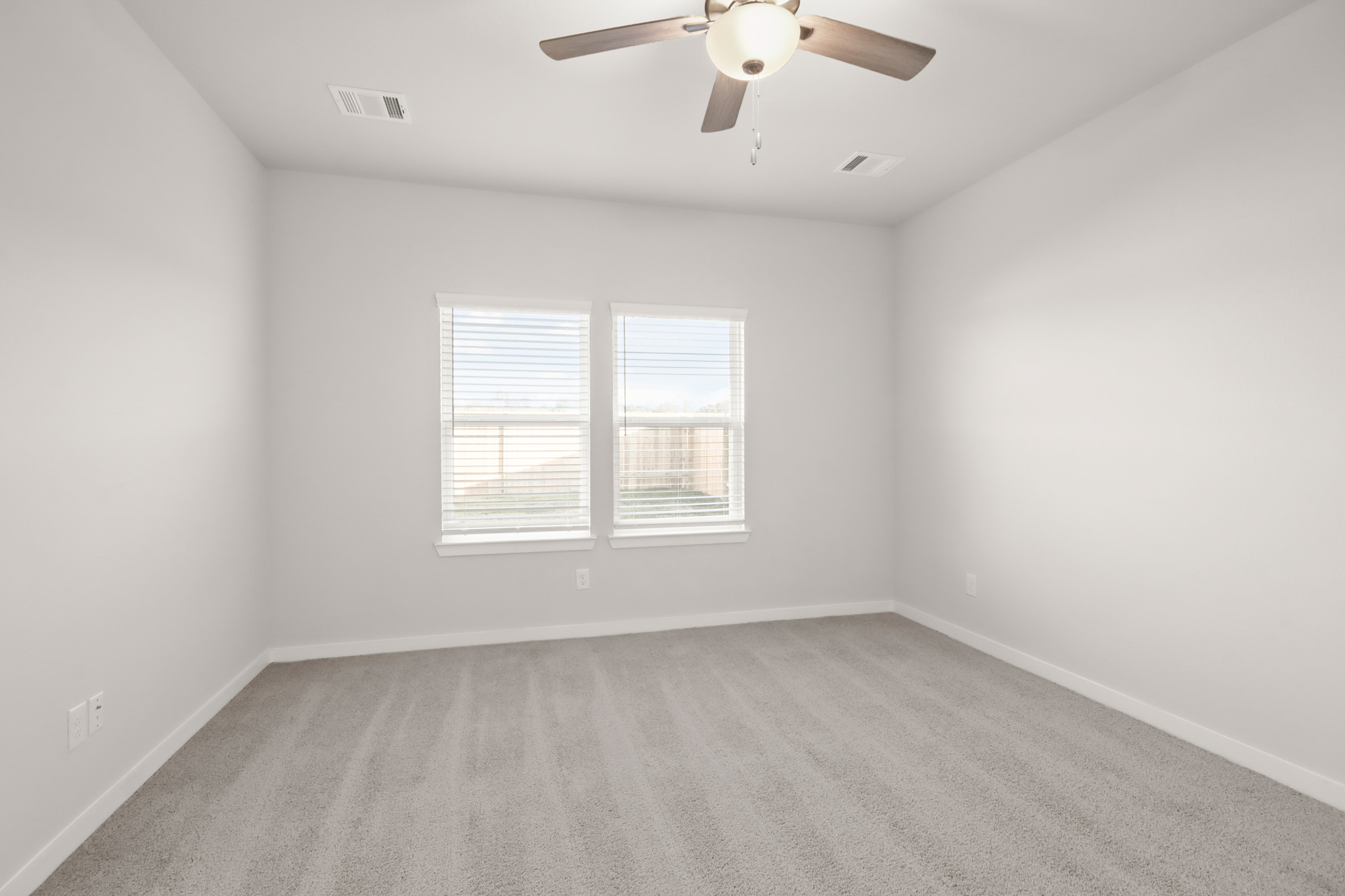 A room with a ceiling fan and a window.