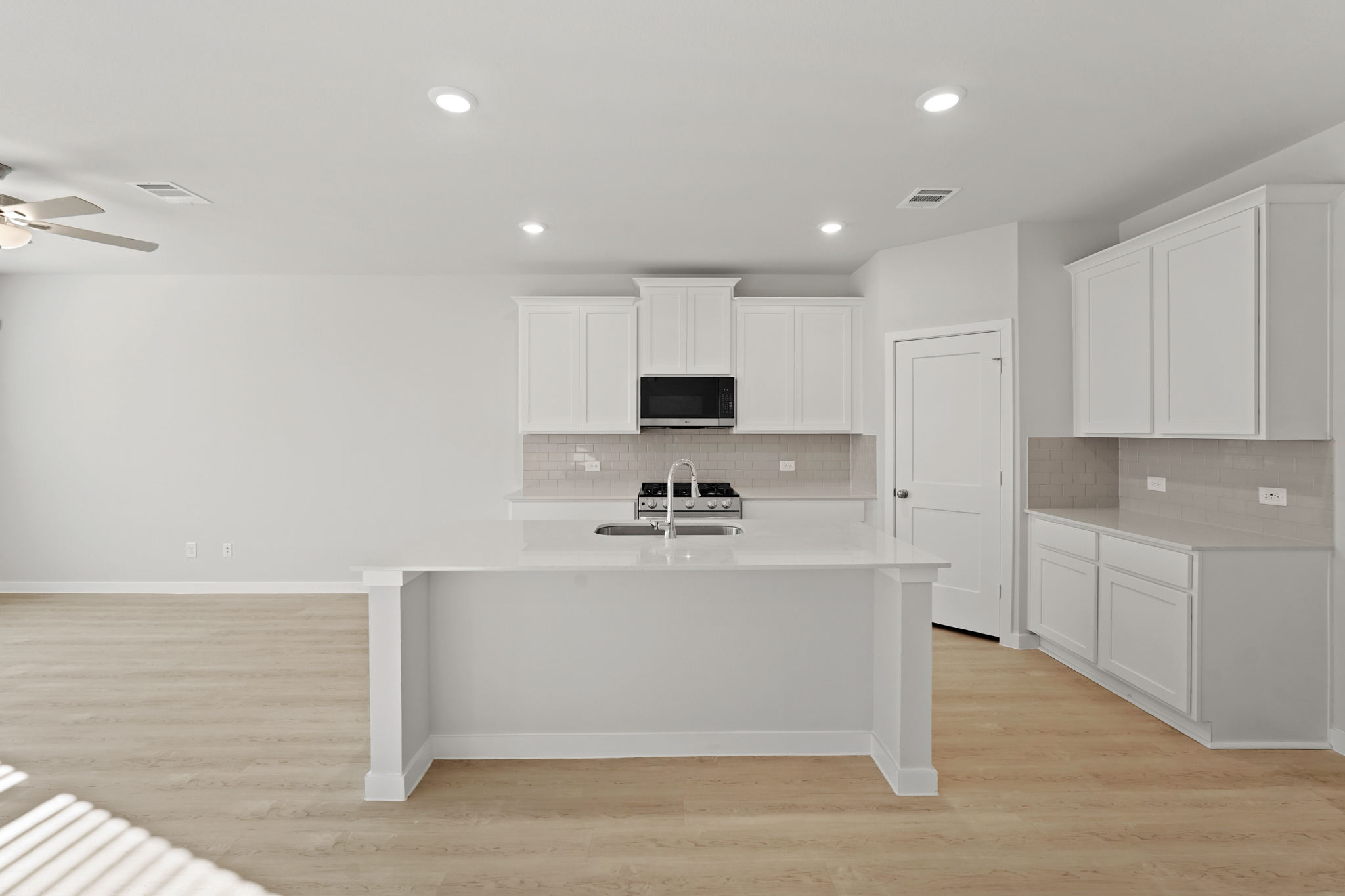 A kitchen with white cabinets.