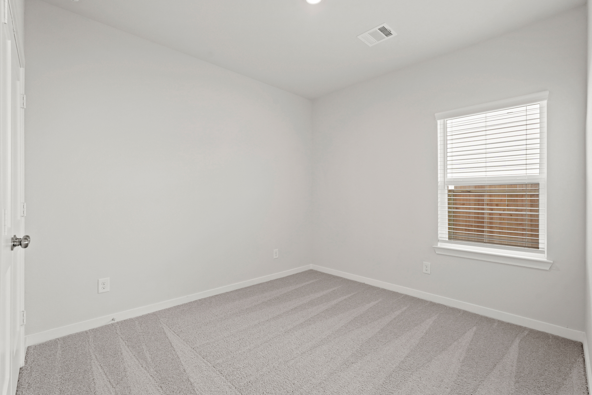 A room with a window and a carpet.