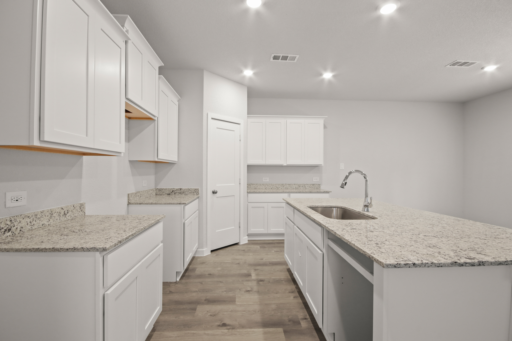 A kitchen with white cabinets.