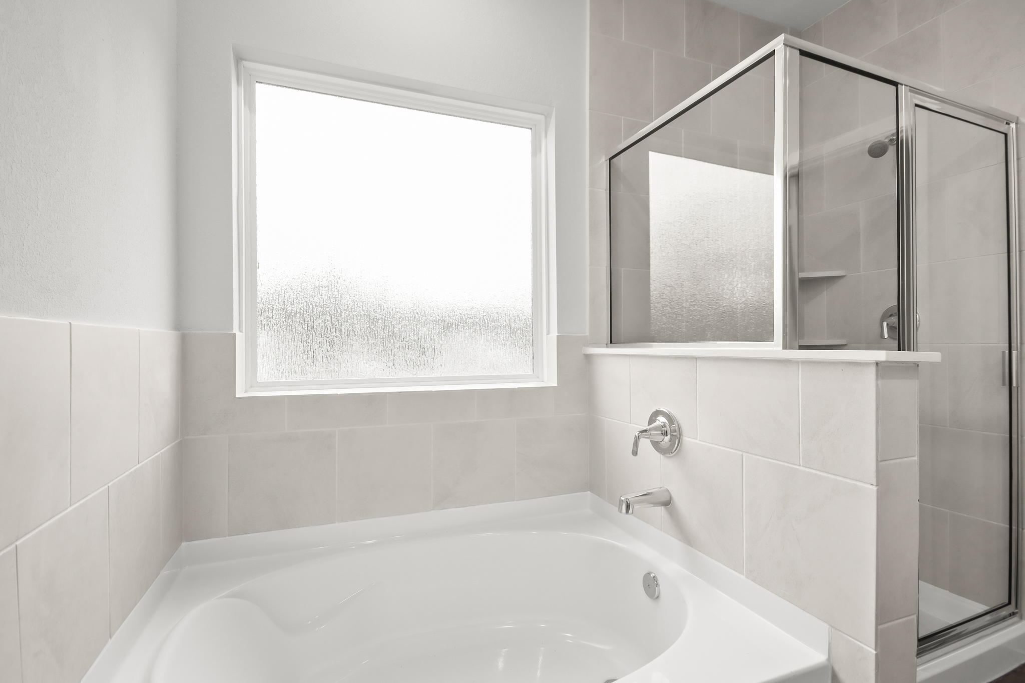 A bathroom with a tub and a window.