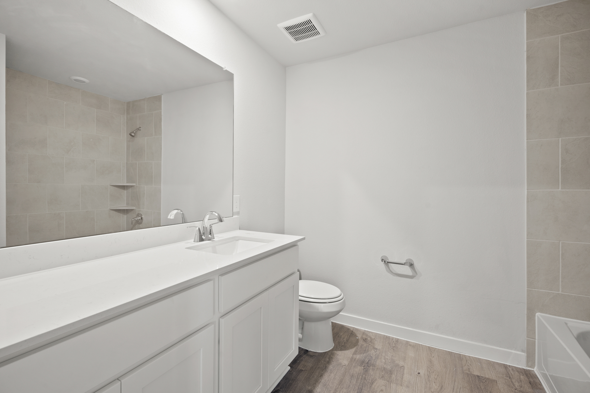 A bathroom with a tub sink and toilet.