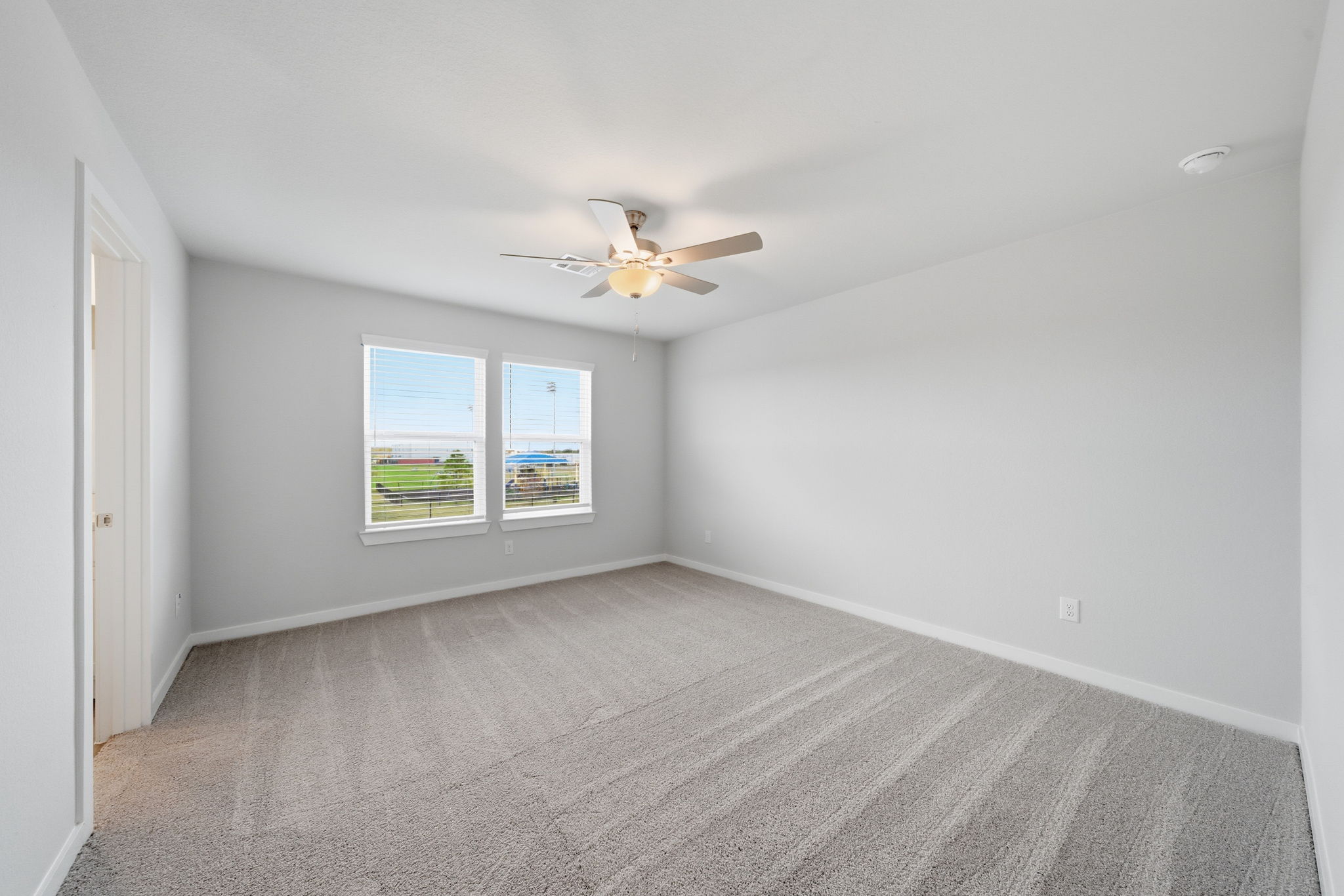 A room with a ceiling fan and a window.