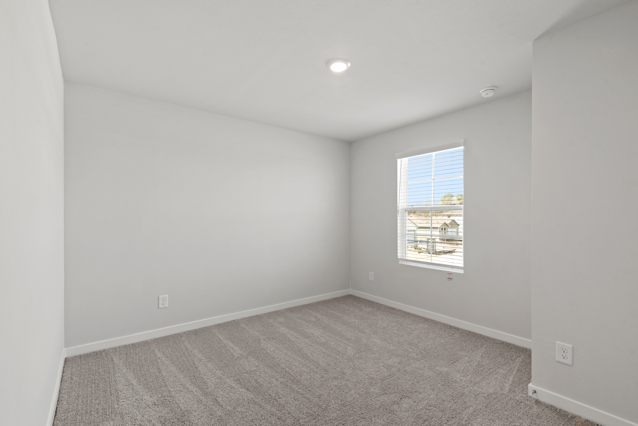 A room with a window and carpet.
