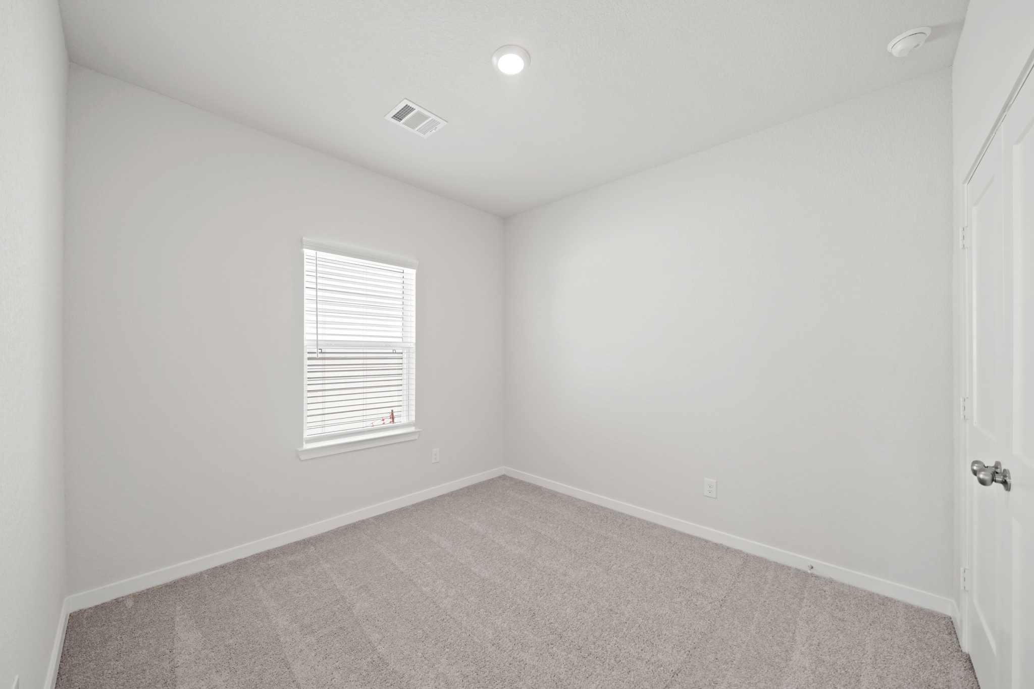 A room with a carpet and a window.