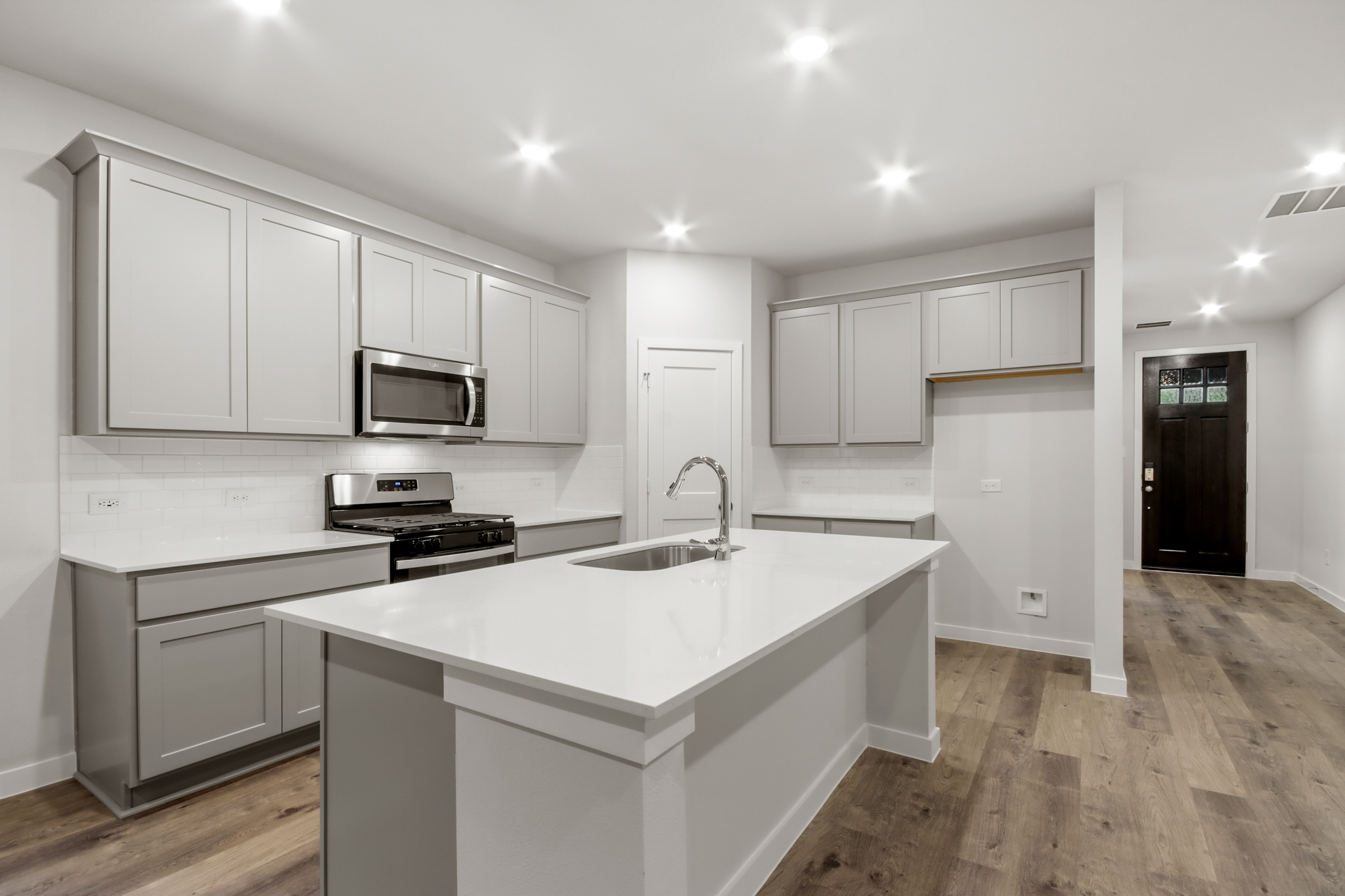 A kitchen with white cabinets.