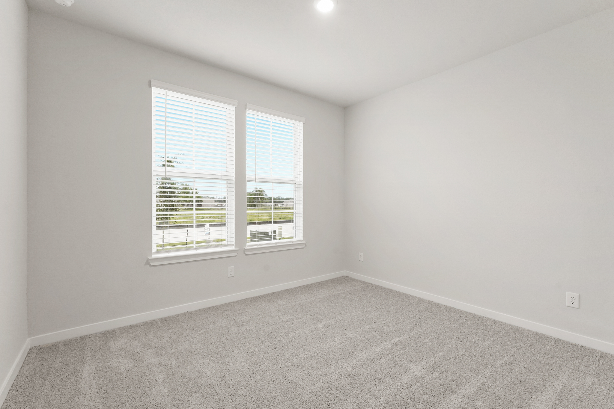 A room with a window and a carpet.