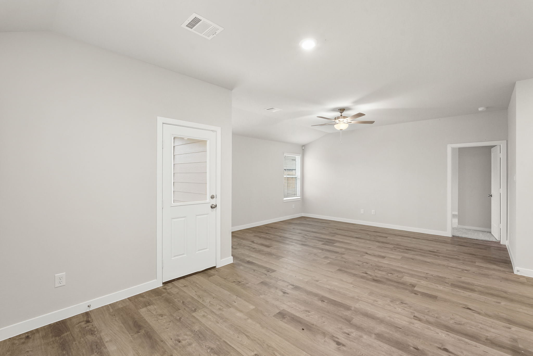 A room with a wood floor and a ceiling fan.