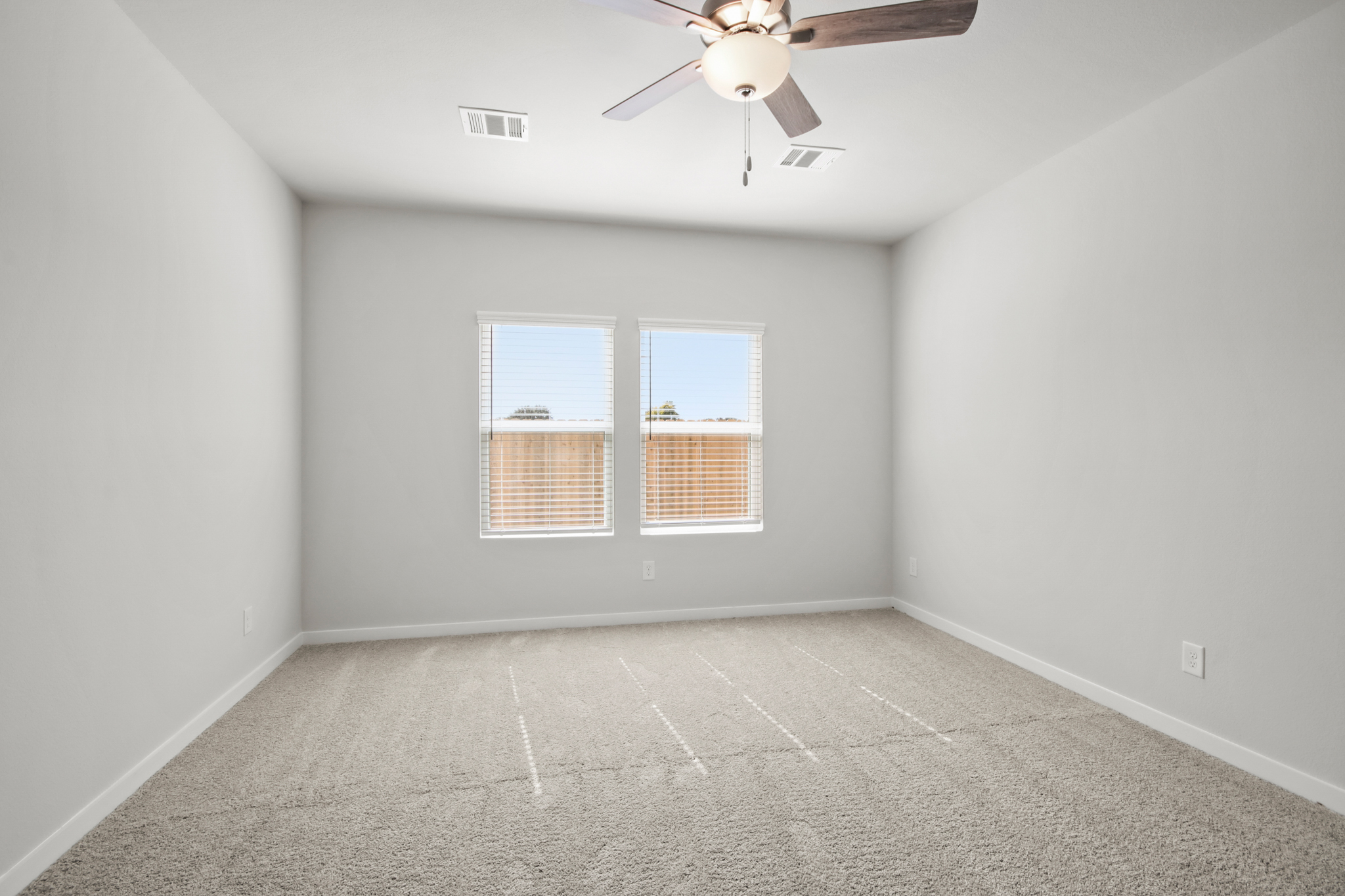 A room with a ceiling fan and a window.