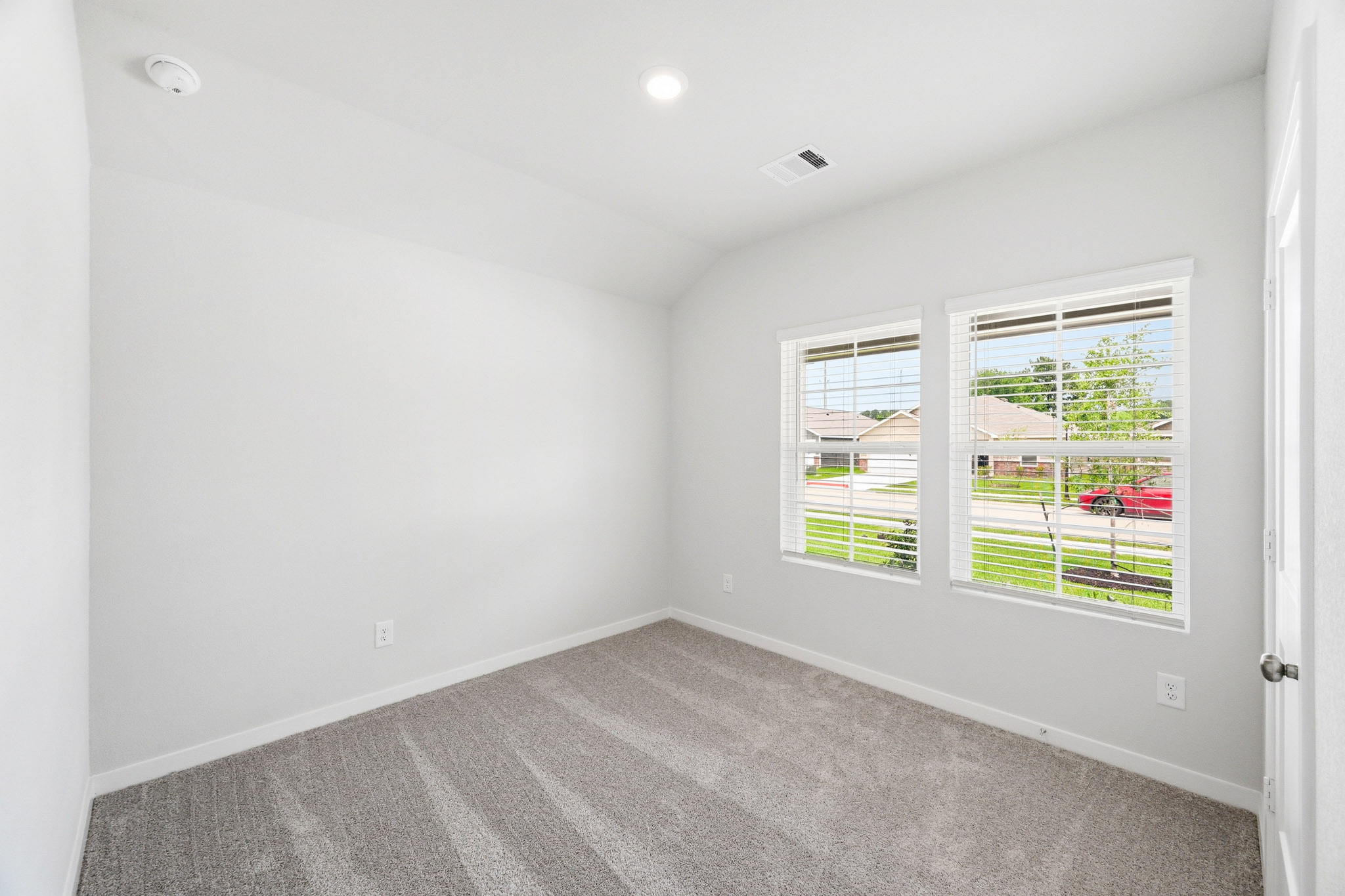 A room with a window and a carpet.