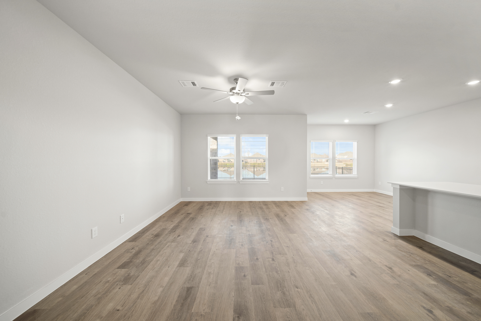 A room with a wood floor and a ceiling fan.
