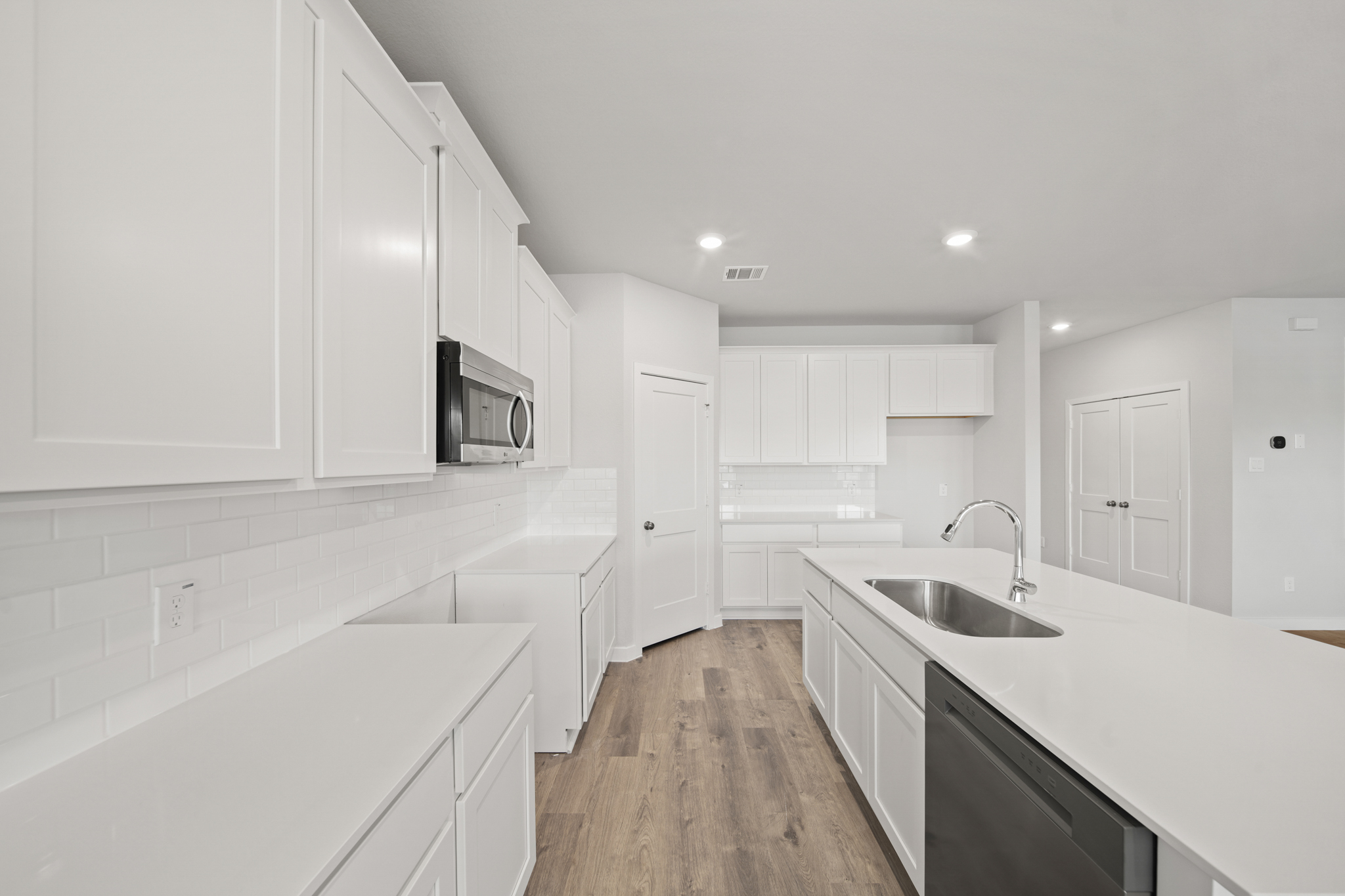 A kitchen with white cabinets.