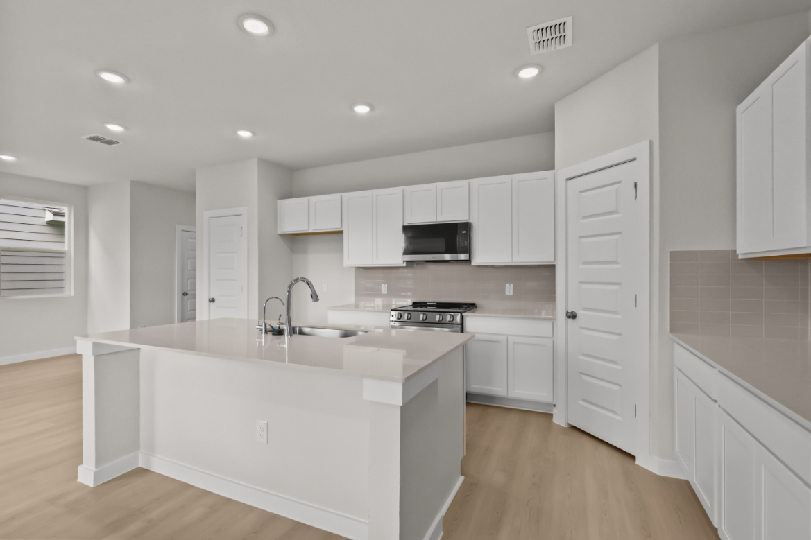 A kitchen with white cabinets.