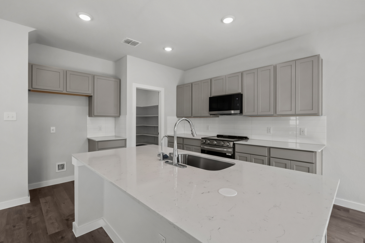 A kitchen with white cabinets.