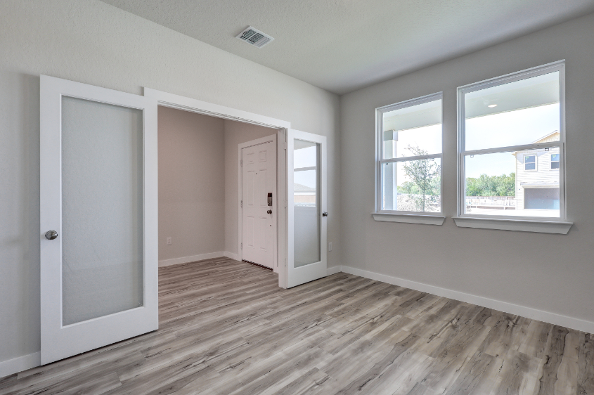 A room with a wood floor and white doors.