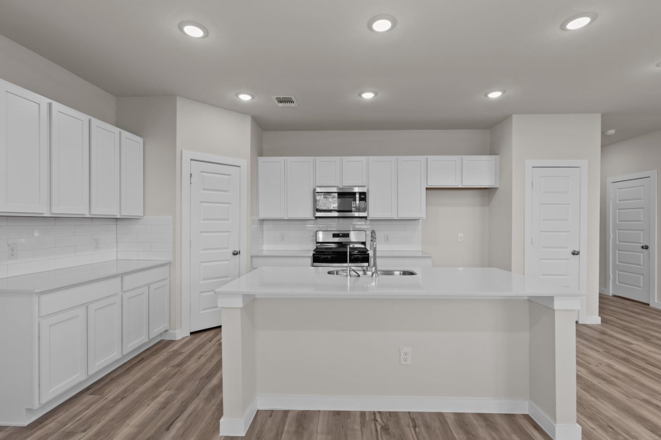 A kitchen with white cabinets.