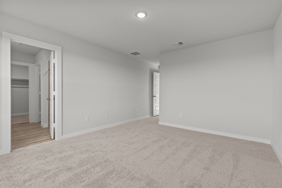 A room with a carpet and a door.