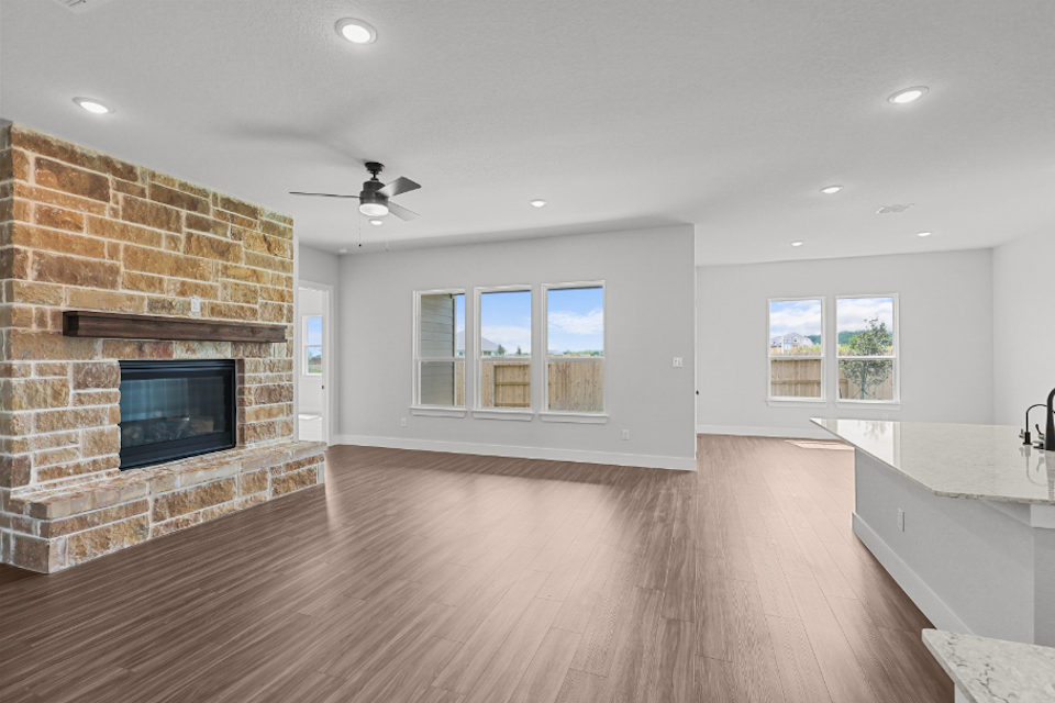 A large room with a fireplace and a wood floor.