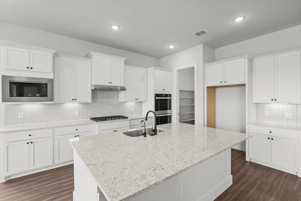 A kitchen with white cabinets.