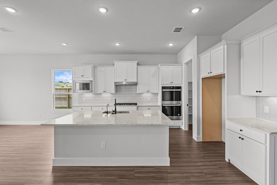 A kitchen with white cabinets.