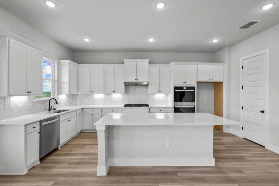 A kitchen with white cabinets.