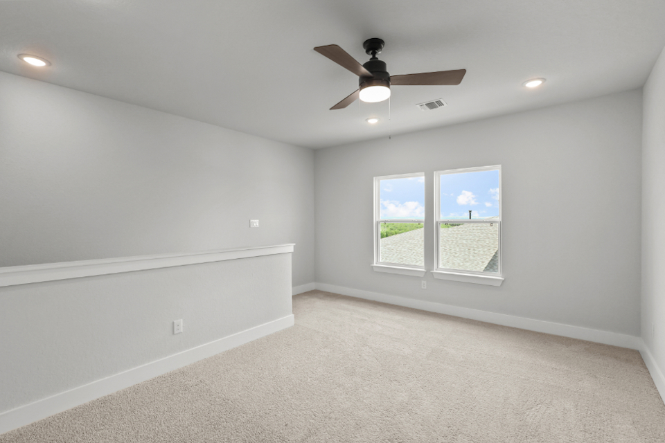 A room with a ceiling fan and a window.