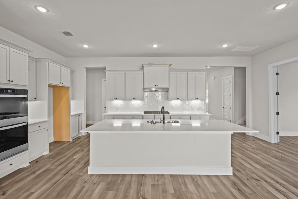 A kitchen with white cabinets.
