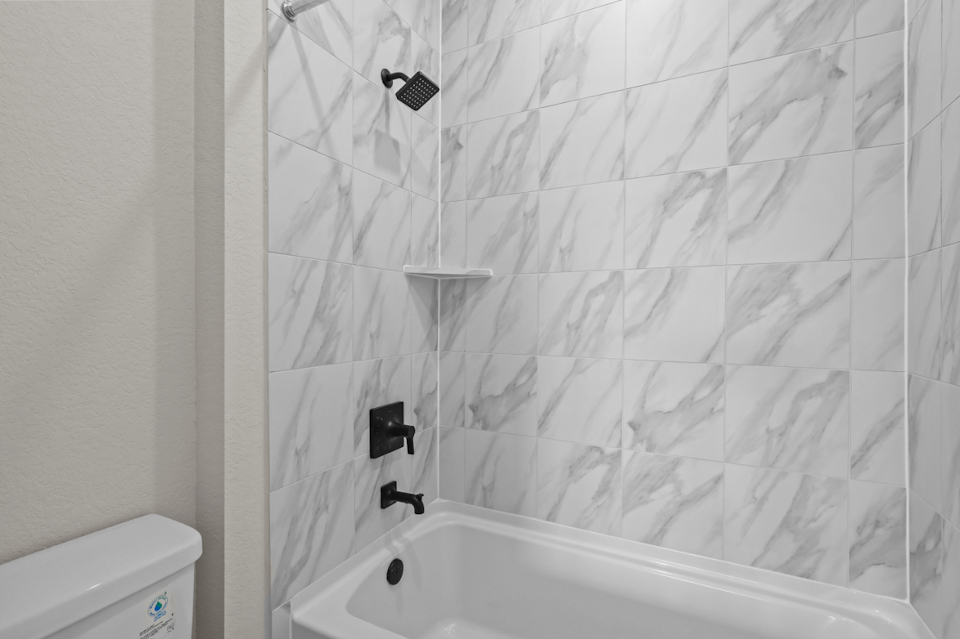 A shower with a tile wall.