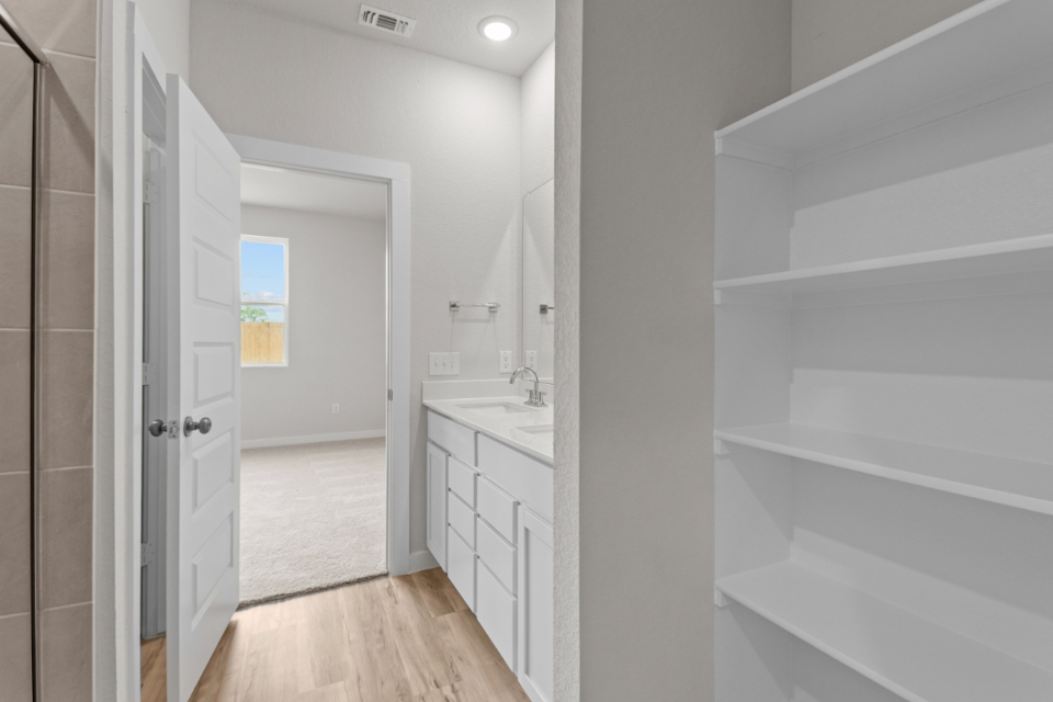 A bathroom with white cabinets.