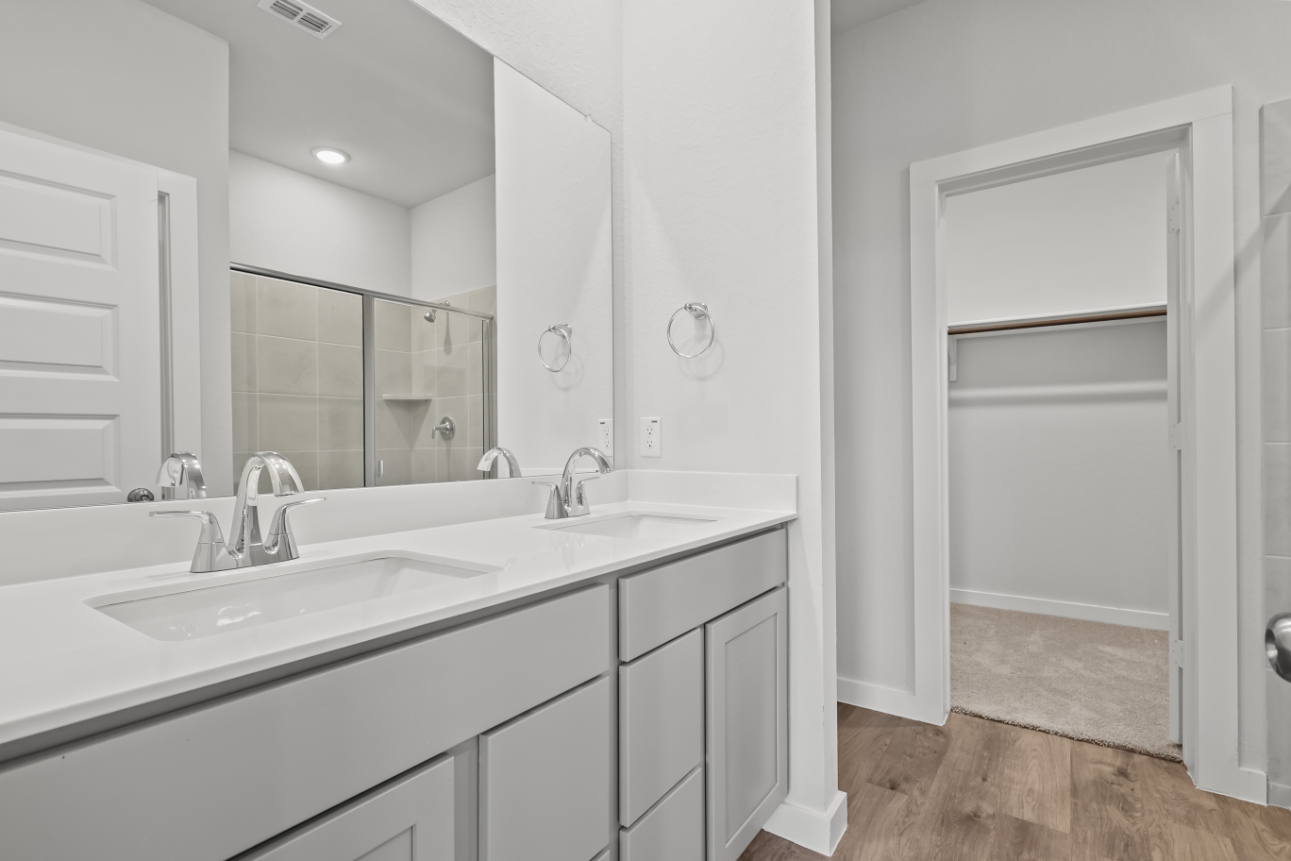 A bathroom with white cabinets.