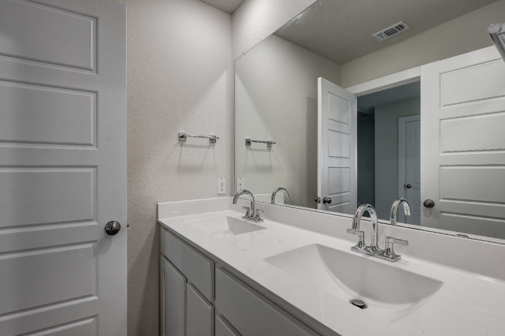 A bathroom with a large mirror.