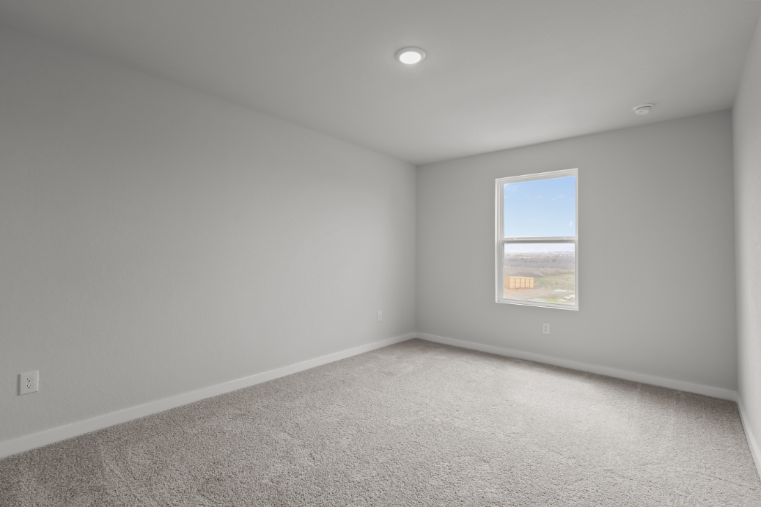 A room with a window and a carpet.