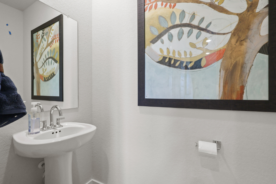 A bathroom with art on the wall.